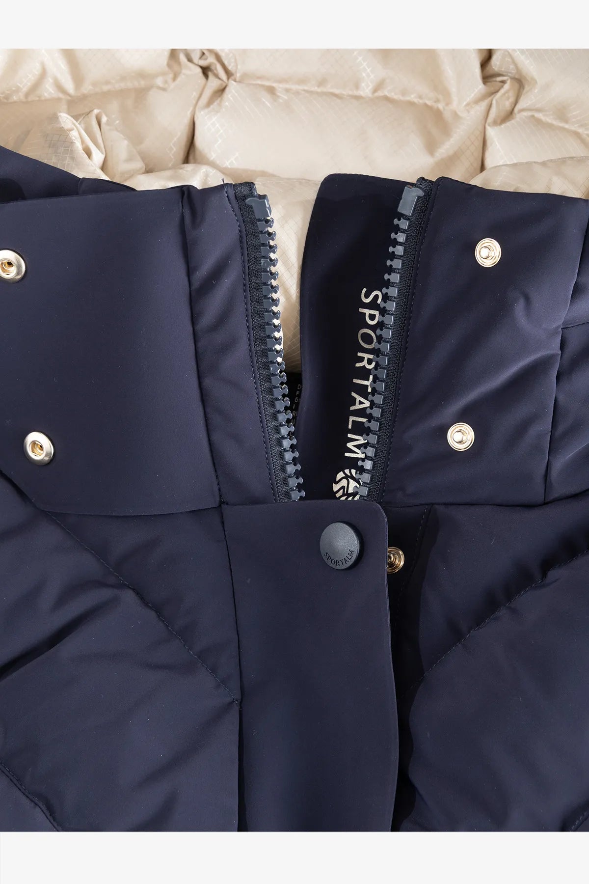 Dunkelblaue, gepolsterte Jacke mit einem Reißverschluss und Druckknöpfen.