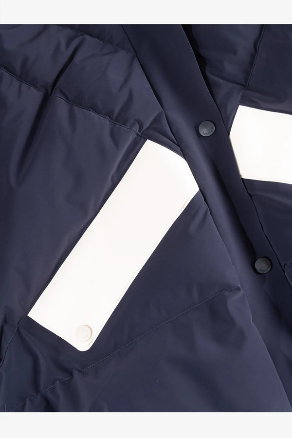 Dunkelblaue Jacke mit weißen Einsatzflächen und Druckknöpfen.